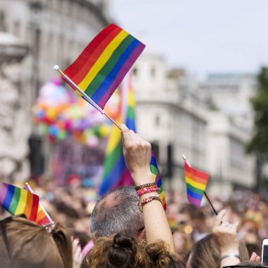 Bir seyirci Lgbt gey yürüyüşünde gey gökkuşağı bayrağı sallıyor 
