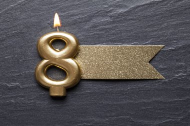 Parıltılı etiketli 8 numaralı kutlama mumu.