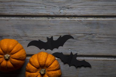 Cadılar Bayramı balkabakları ve tahta arka planda kara vampir yarasalar