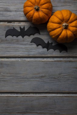 Cadılar Bayramı balkabakları ve tahta arka planda kara vampir yarasalar