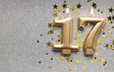 Yıldız ve ışıltılı arka plan üzerinde Sayı 17 altın kutlama mum