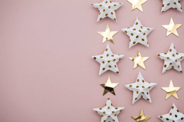 Pastel pembe üzerine beyaz ve altın yıldız süslemeleri. Mevsimlik fetiş