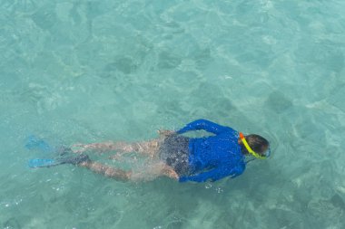 Açık mavi tropikal denizde homurdanan bir kadın