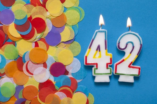 # 42 slavnostní svíčka s party konfety — Stock fotografie