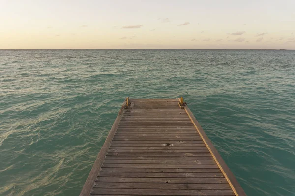 Muelle de madera sobre el mar tropical al atardecer — Foto de Stock