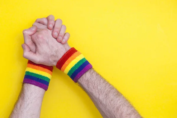 Podpůrné ruce s gay pýchou duha vlajka náramek na křik — Stock fotografie