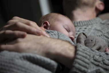 Oğlunu göğsünde tutan bir baba. Aile bağı. Babalık