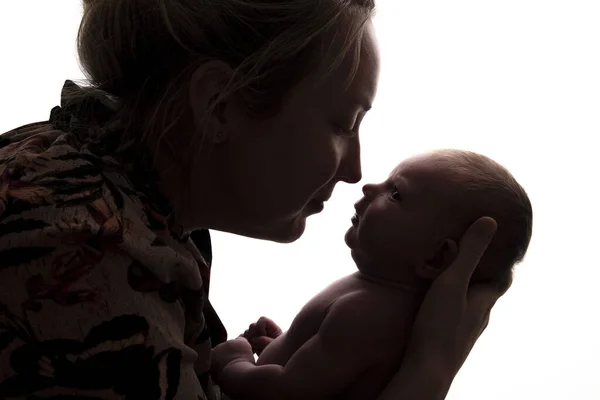 Silueta de una madre sosteniendo a su bebé recién nacido —  Fotos de Stock