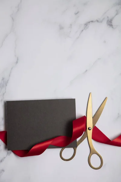 Grand opening background. Gold scissors with red ribbon on a marble background — Stock Photo, Image