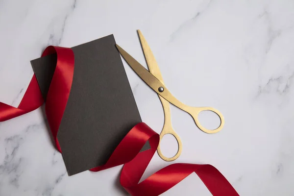 Grand opening background. Gold scissors with red ribbon on a marble background — Stock Photo, Image
