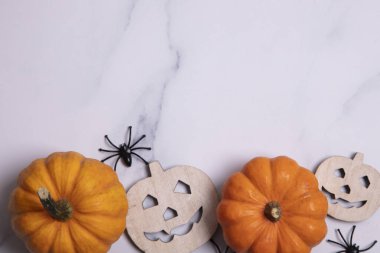 Cadılar Bayramı kompozisyonu. Balkabakları ve örümcekler mermer arka planda. düz yat