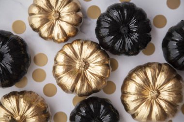 Lüks altın ve siyah sonbahar balkabağı düz bir mermer zemin üzerinde yatıyordu