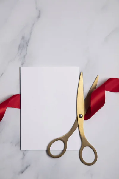 Grand opening background. Gold scissors with red ribbon on a marble background — Stock Photo, Image