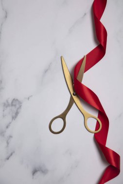 Büyük açılış arka planı. Mermer zemin üzerinde kırmızı kurdeleli altın makas