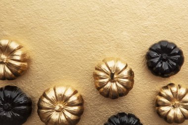 Lüks altın ve siyah sonbahar balkabağı düz altın bir zemin üzerine serili