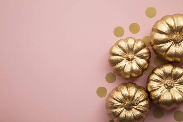 Hermosas calabazas doradas en rosa pastel. Composición plana de acción de gracias —  Fotos de Stock