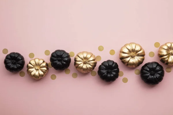 Calabazas doradas y negras sobre rosa pastel. Composición plana de acción de gracias —  Fotos de Stock