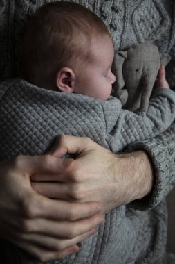 Oğlunu göğsünde tutan bir baba. Aile bağı. Babalık