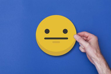 Bir emoji simgesi tutan erkek el gülümseyen kafa simgesi