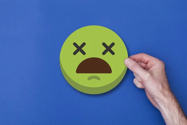 Männliche Hand mit einem Emoji-Emoticon Smiley-Kopf-Symbol — Stockfoto