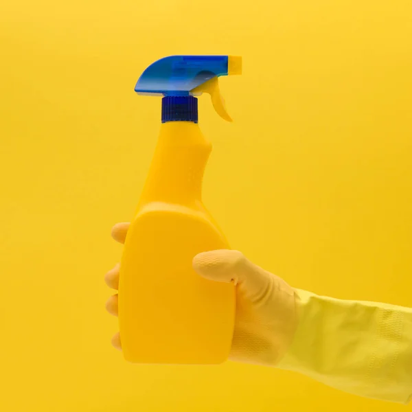 Ręka w żółtej gumowej rękawicy z produktem czyszczącym — Zdjęcie stockowe