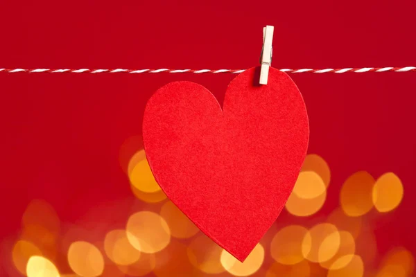 Червоний папір форма серця прив'язаний до струни з розмитим боке світлом — стокове фото