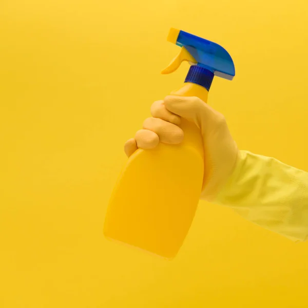 Hand in gelben Gummihandschuh mit Reinigungsmittel — Stockfoto