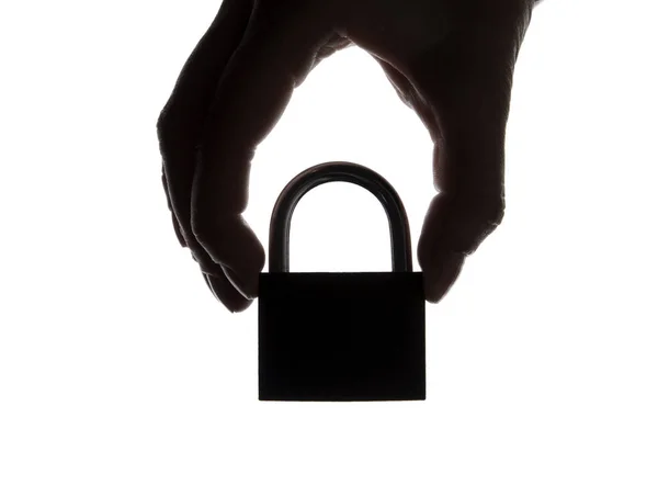 Silhouette of a hand holding a padlock on a plain white backgrou — Stock Photo, Image
