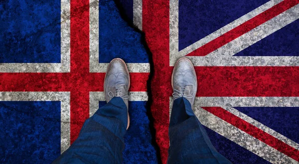 Uomo d'affari si erge sulla bandiera incrinata del Regno Unito e dell'Islanda. Concetto politico — Foto Stock