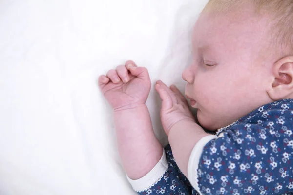 Newborn baby asleep on a white sheet. Cute young baby — Stock Photo, Image