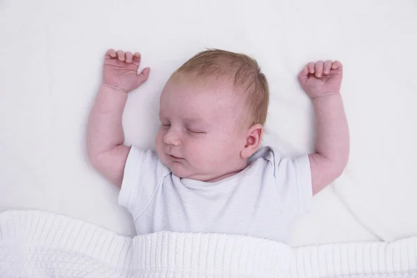 A sleeping young baby with their arms up. Cute baby asleep — Stock Photo, Image