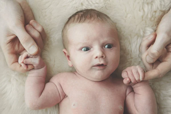 Um bebê bonito segura o dedo dos pais. Conceito de paternidade — Fotografia de Stock