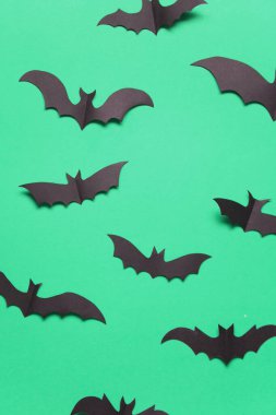 Yeşil arka planda Cadılar Bayramı kağıt vampir yarasa süslemeleri.