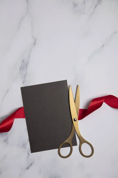 Grand opening background. Gold scissors with red ribbon on a marble background — Stock Photo, Image