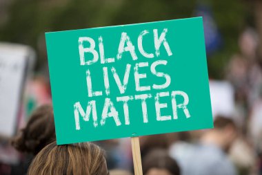Bir protestoda elinde siyah hayatı taşıyan kişi önemli bir pankart taşıyor.
