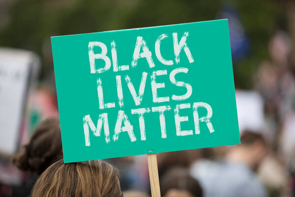 A person holding a black lives matter banner at a protest