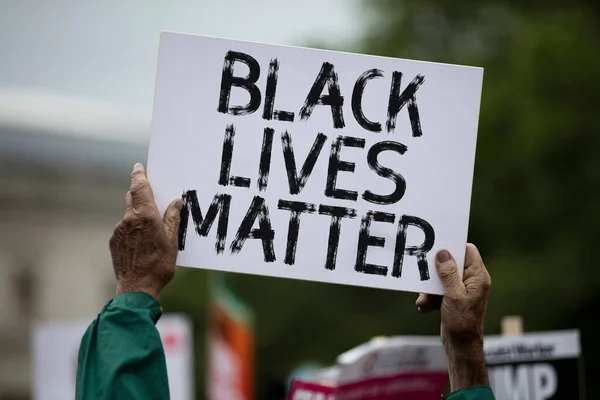 Una persona che tiene uno stendardo nero della materia di vita ad una protesta — Foto Stock