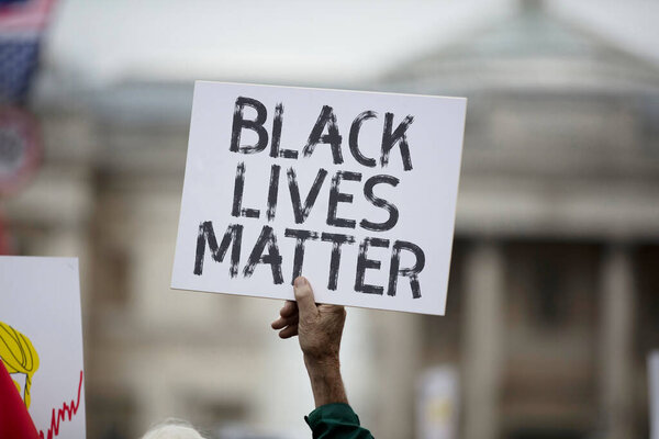 A person holding a black lives matter banner at a protest