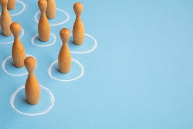 Sosyal uzaklık kavramı. Tahta figürler beyaz daireler çizer.