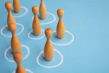 Sosyal uzaklık kavramı. Tahta figürler beyaz daireler çizer.