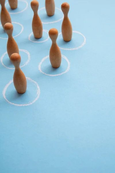 Concept de distance sociale. Figurines en bois debout en cercles blancs — Photo