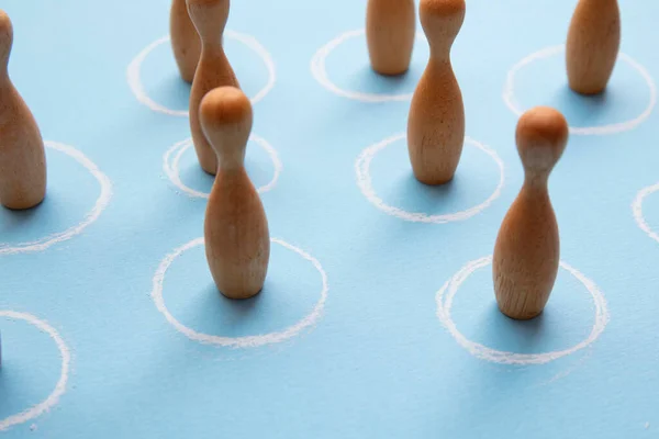 Concepto de distanciamiento social. Figuras de madera en círculos blancos —  Fotos de Stock