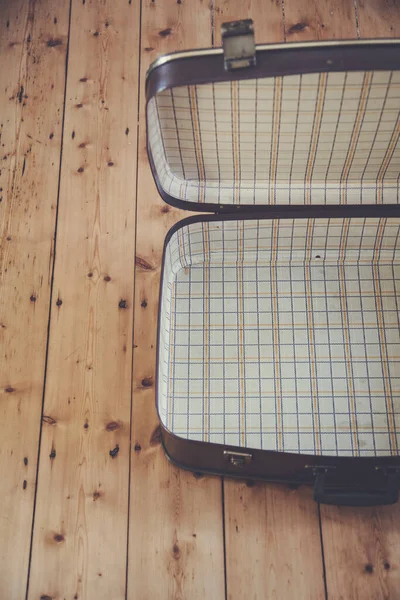 Відкрита стара старовинна коричнева валіза для подорожей на дерев'яній підлозі — стокове фото