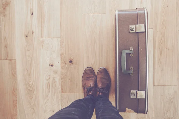 Looking down towards a persons feet and old vintage travel suitcase — Stock Photo, Image