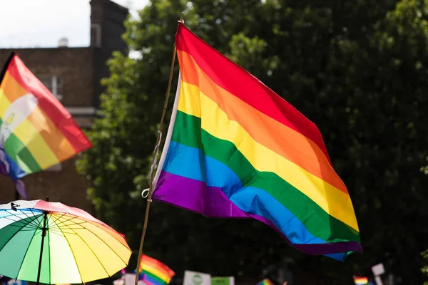 Gay Pride: LGBTQ-Regenbogenfahnen werden bei einer Pride-Veranstaltung in der Luft geschwenkt — Stockfoto