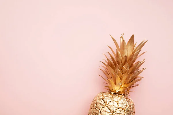 Guld tropisk ananas på en pastellrosa bakgrund. Platt låg sommar bakgrund — Stockfoto