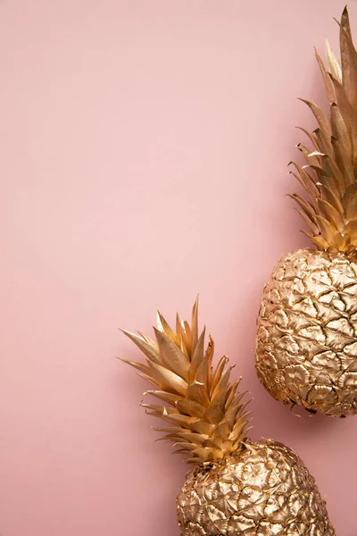 Gouden tropische ananas op een pastelroze achtergrond. Vlakke lay zomer achtergrond — Stockfoto