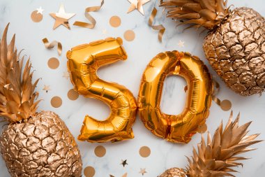 Altın folyo balonlar ve altın ananaslarla dolu 50. yaş günü kartı