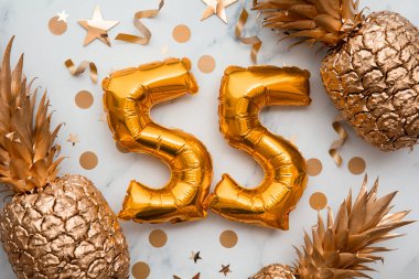 Altın folyo balonlar ve altın ananaslarla dolu 55. Doğum günü kartı