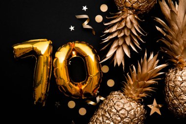 70. yaş günü kutlamaları altın balonlar ve altın ananaslarla dolu.